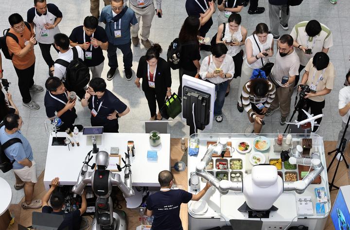 图为7月17日，参观者在世博展览馆内观看机器人技能展示。新华社记者方喆 摄 